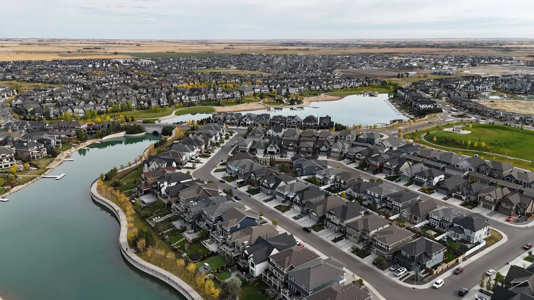 Aerial view of Mahogany in autumn: homes backing onto the lake promenade, interior streets, a park and the main lake and beach